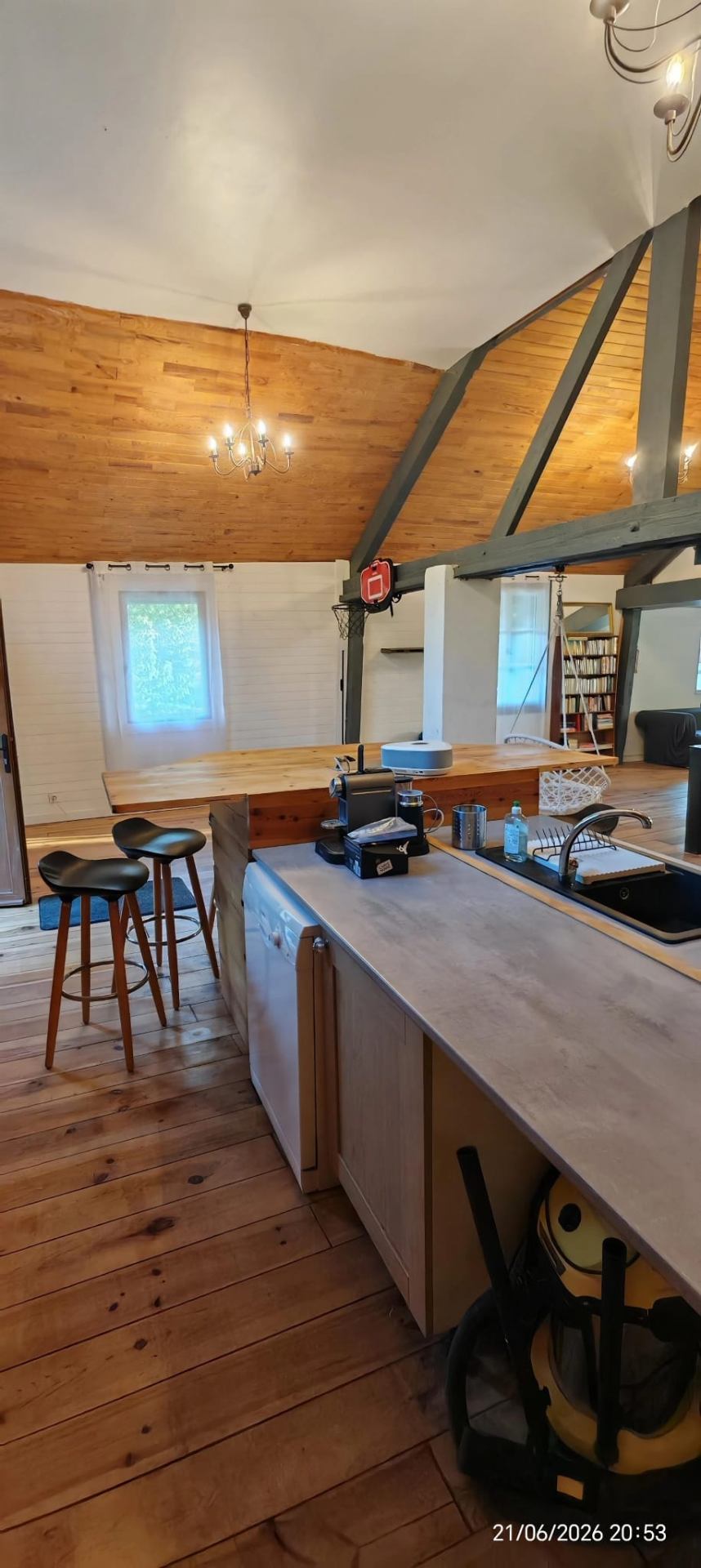 Cuisine équipée avec îlot central et coin bar